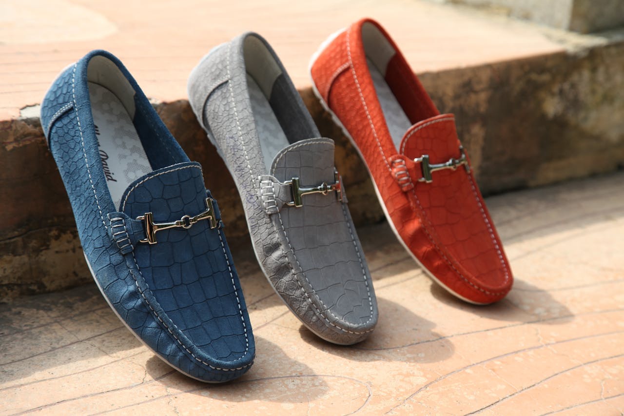 services-04 Three colorful leather loafers displayed outdoors showcasing style and elegance.