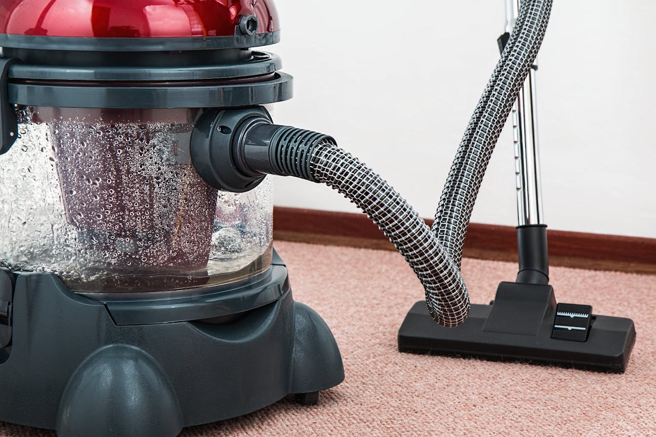 services-img Close-up of a modern vacuum cleaner with water filtration on carpet floor indoors.