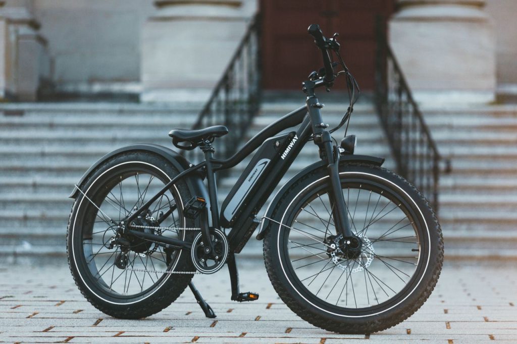 Sleek black electric bike parked on city steps, showcasing urban mobility.
